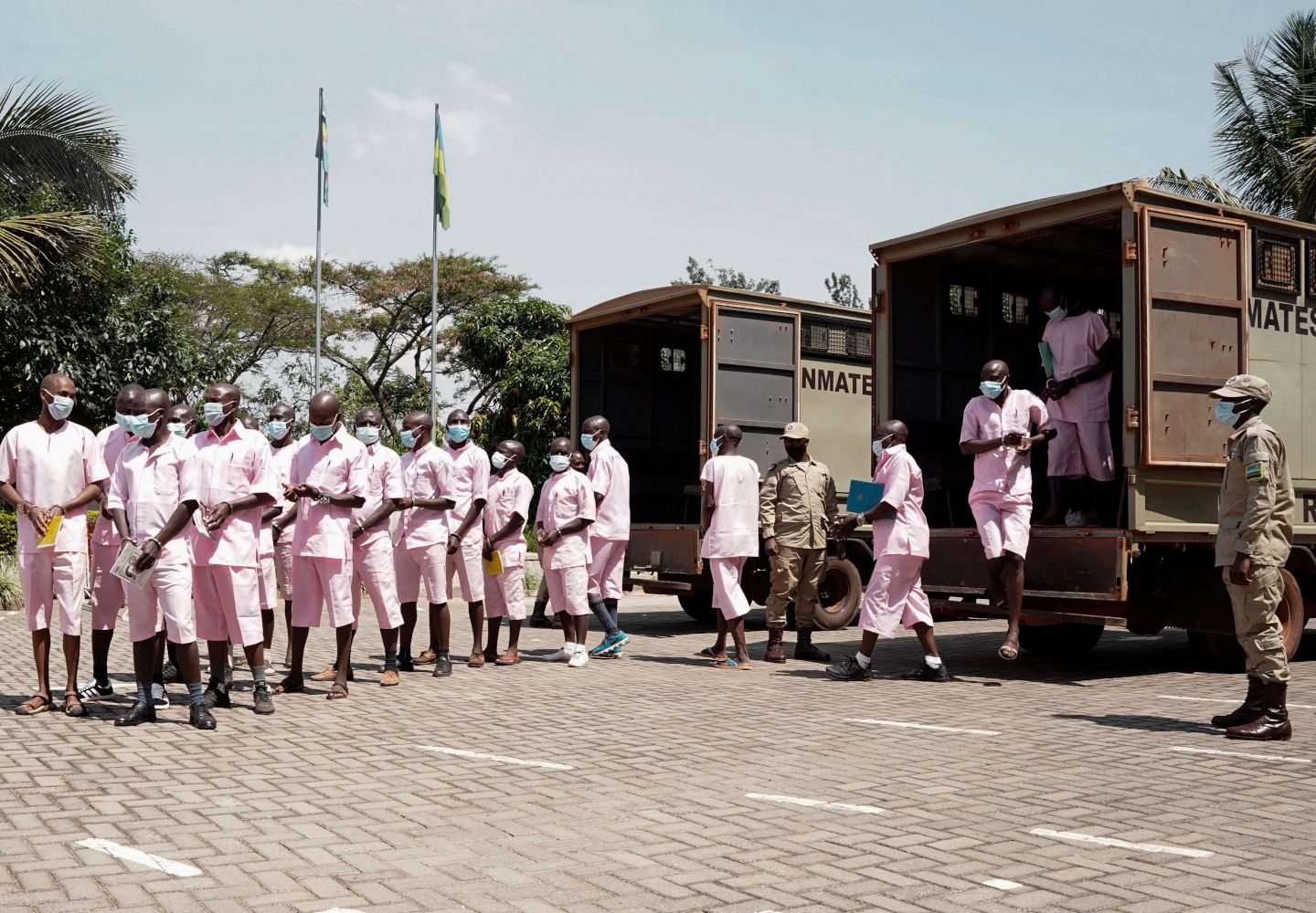 Foto af 20 tiltalte, der er i færd med at blive ført ud af en fangetransport i forbindelse med en retssag om terrorisme ved Rwandas højesteret.