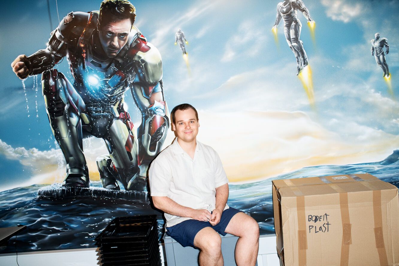 Mathias Nielsen siddende foran en væg, hvor Iron Man er malet på