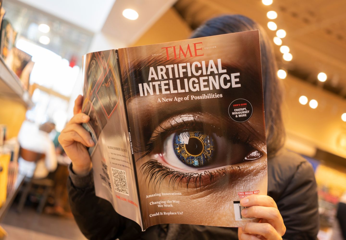 Foto af en person, der læser et magasin, hvor der på forsiden står "Artificial Intelligence"