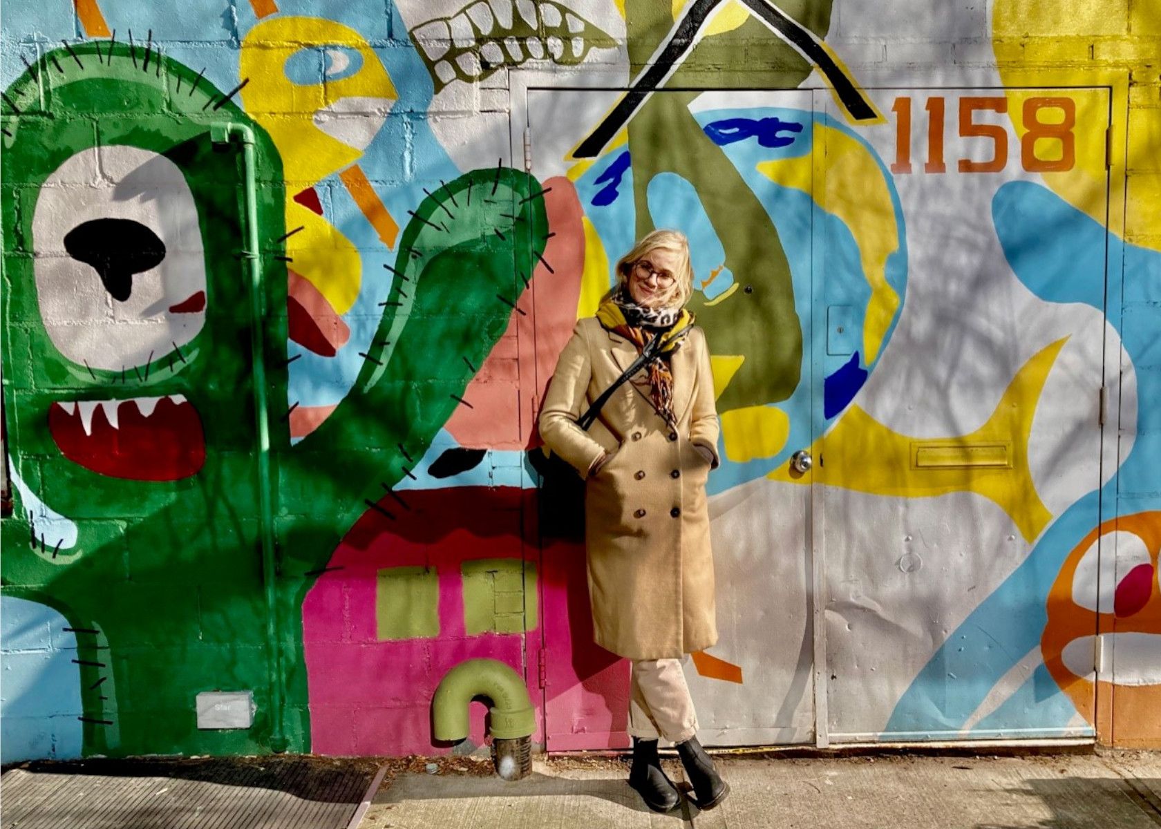 Maja Friis står foran væg med grafitti.