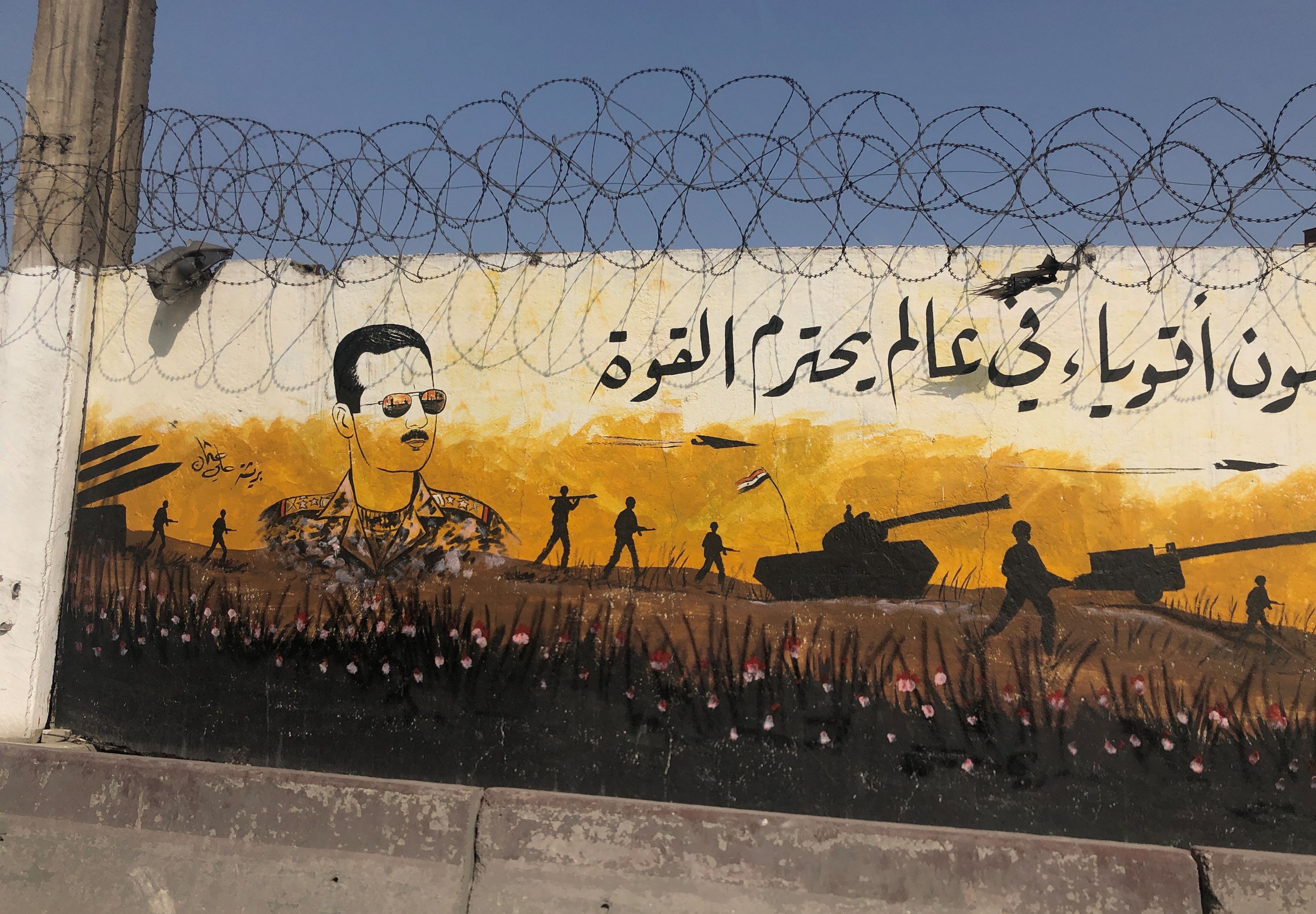Foto af syrisk mur-maleri, der henviser til borgerkrigen i landet