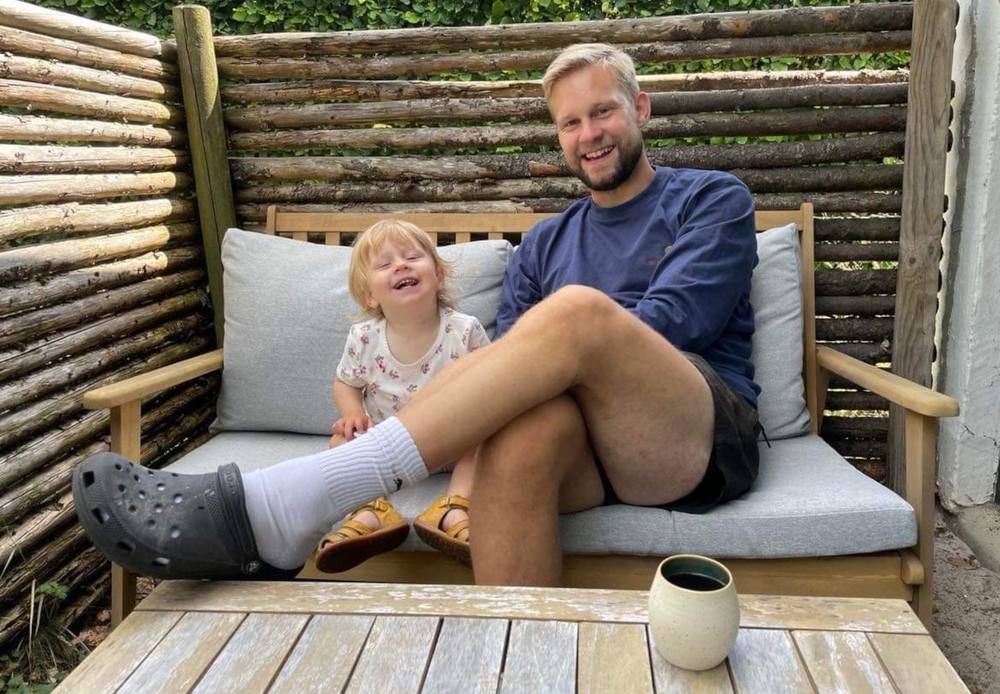 Foto af Johan Denning og hans barn i en sofa på terrassen